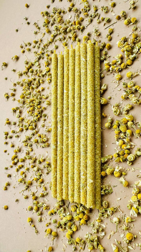 Velas decorativas de cera pura de abeja, enrolladas en flores secas de manzanilla para un ambiente natural y sereno.